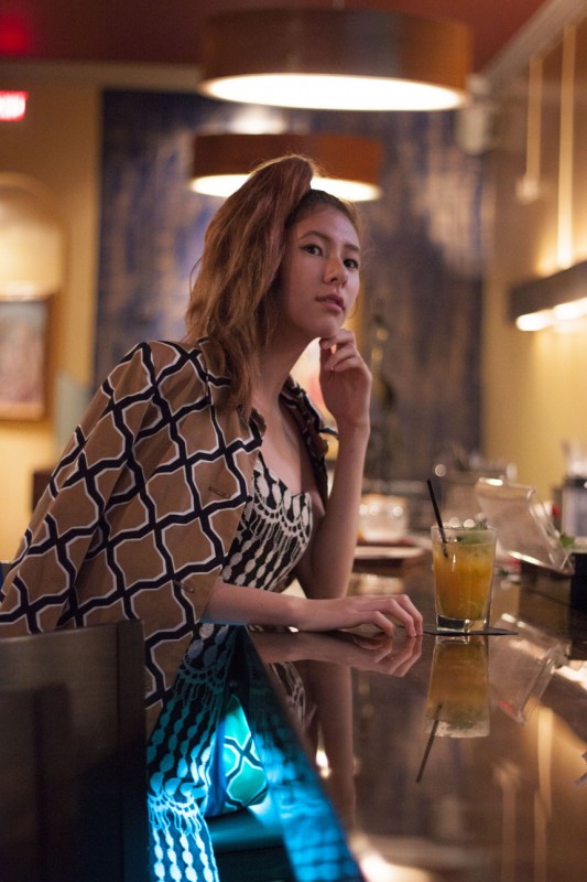 Waiting at Andaz's bar, Mizusawa is donning an Xtaren black and white polka dot dress, a geometric print bespoke coat and gold earrings. Photos courtesy of Ronan Galvez.